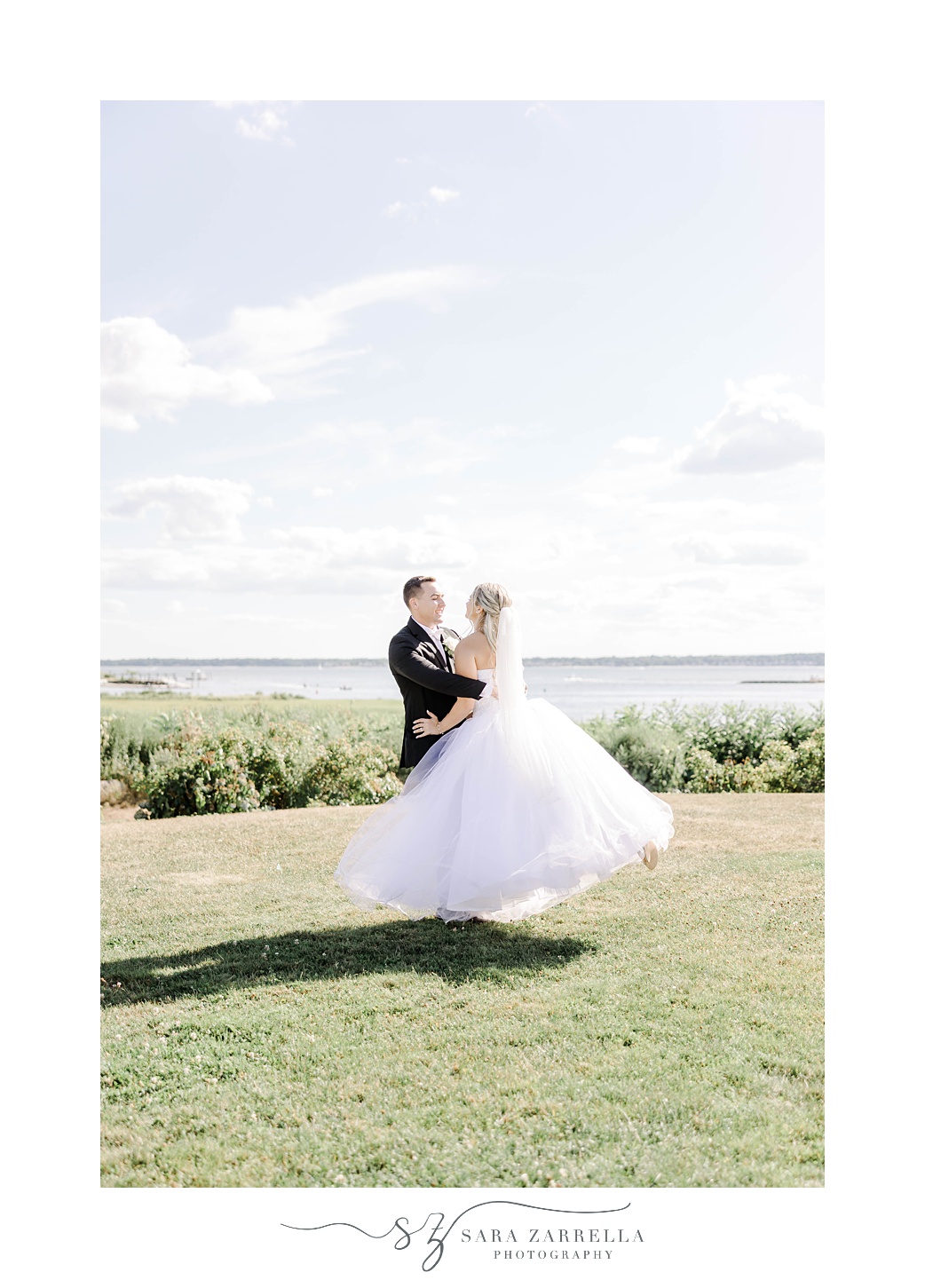 groom twirls bride on hill at Harbor Lights