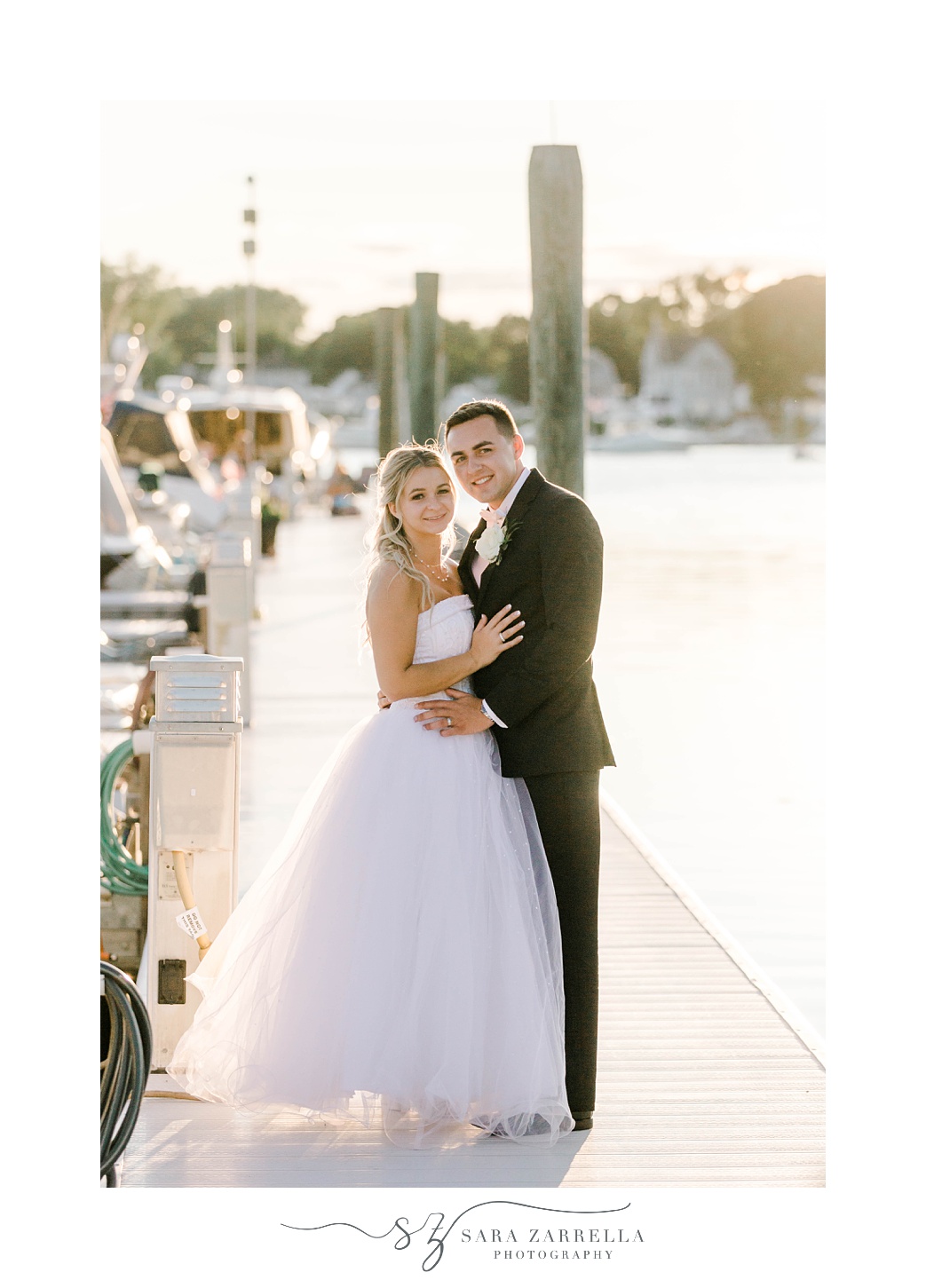 newlyweds hug on dock at Harbor Lights