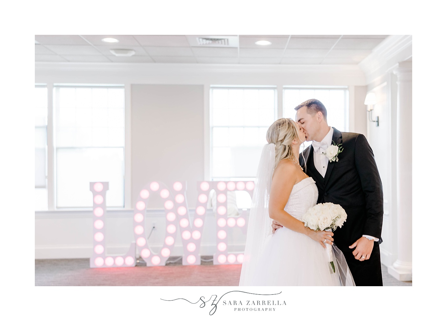 newlyweds kiss by LOVE marquee at Warwick RI wedding reception