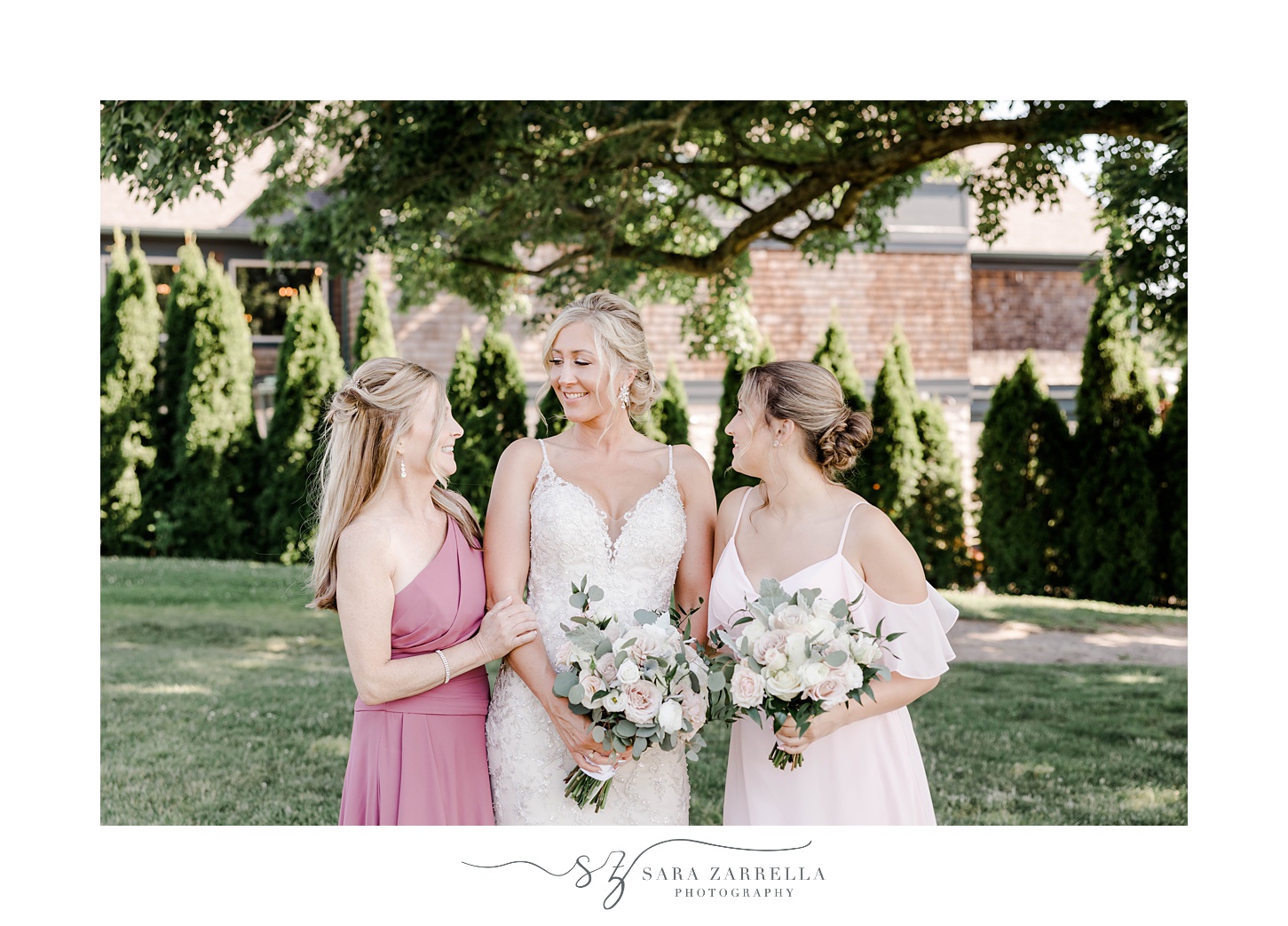 bride smiles with bridesmaid and mother 