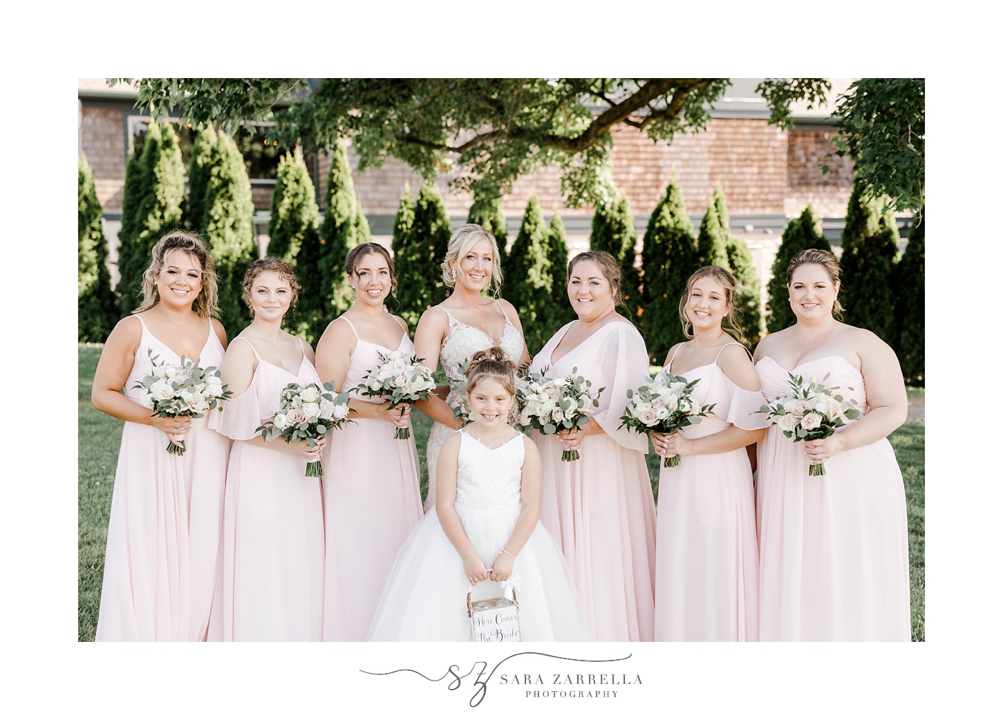 bride and bridesmaids in pink gowns pose at Harbor Lights