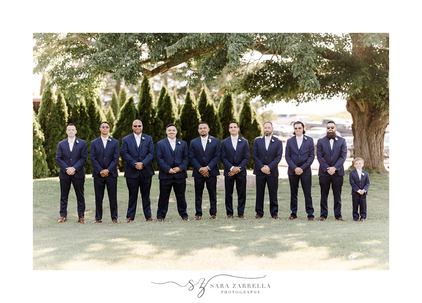 groom stands with groomsmen in navy suits