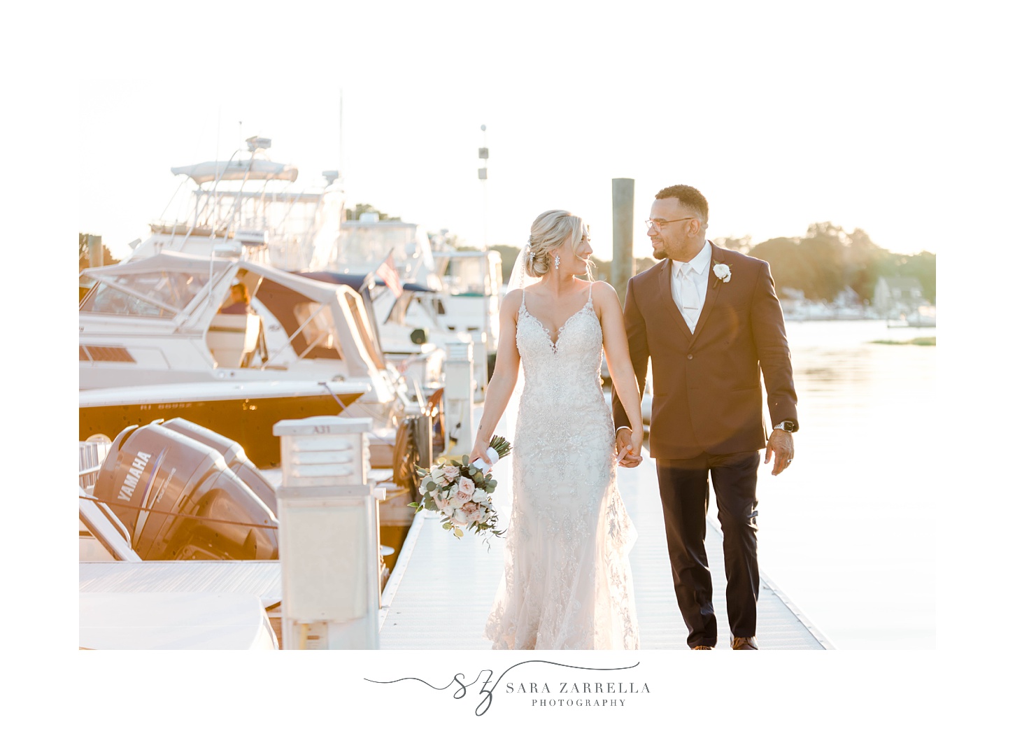 bride and groom hold hands walking at sunset at Harbor Lights