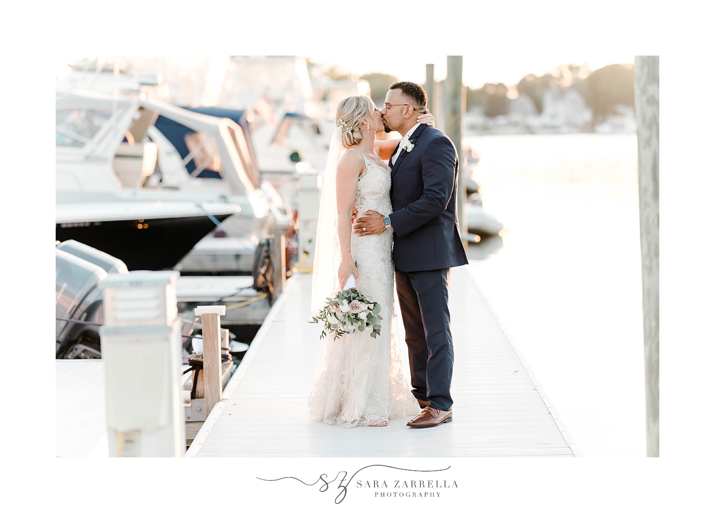 bride and groom kiss on dock during portraits at Harbor Lights