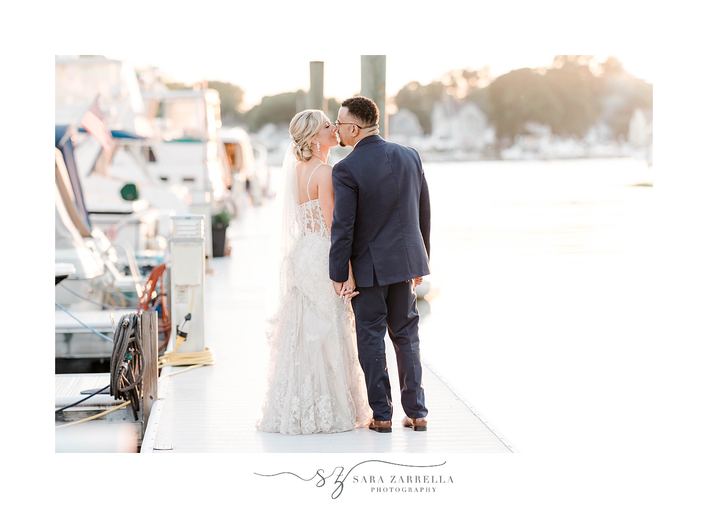 bride and groom kiss on dock at Harbor Lights