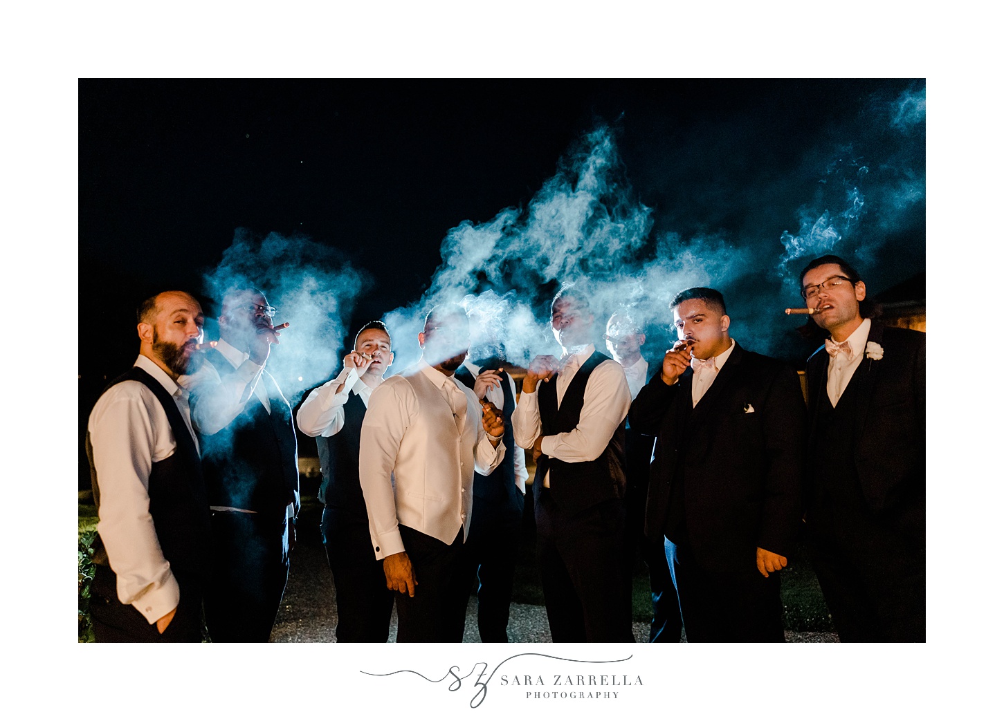 groom and groomsmen smoke at night outside Harbor Lights 