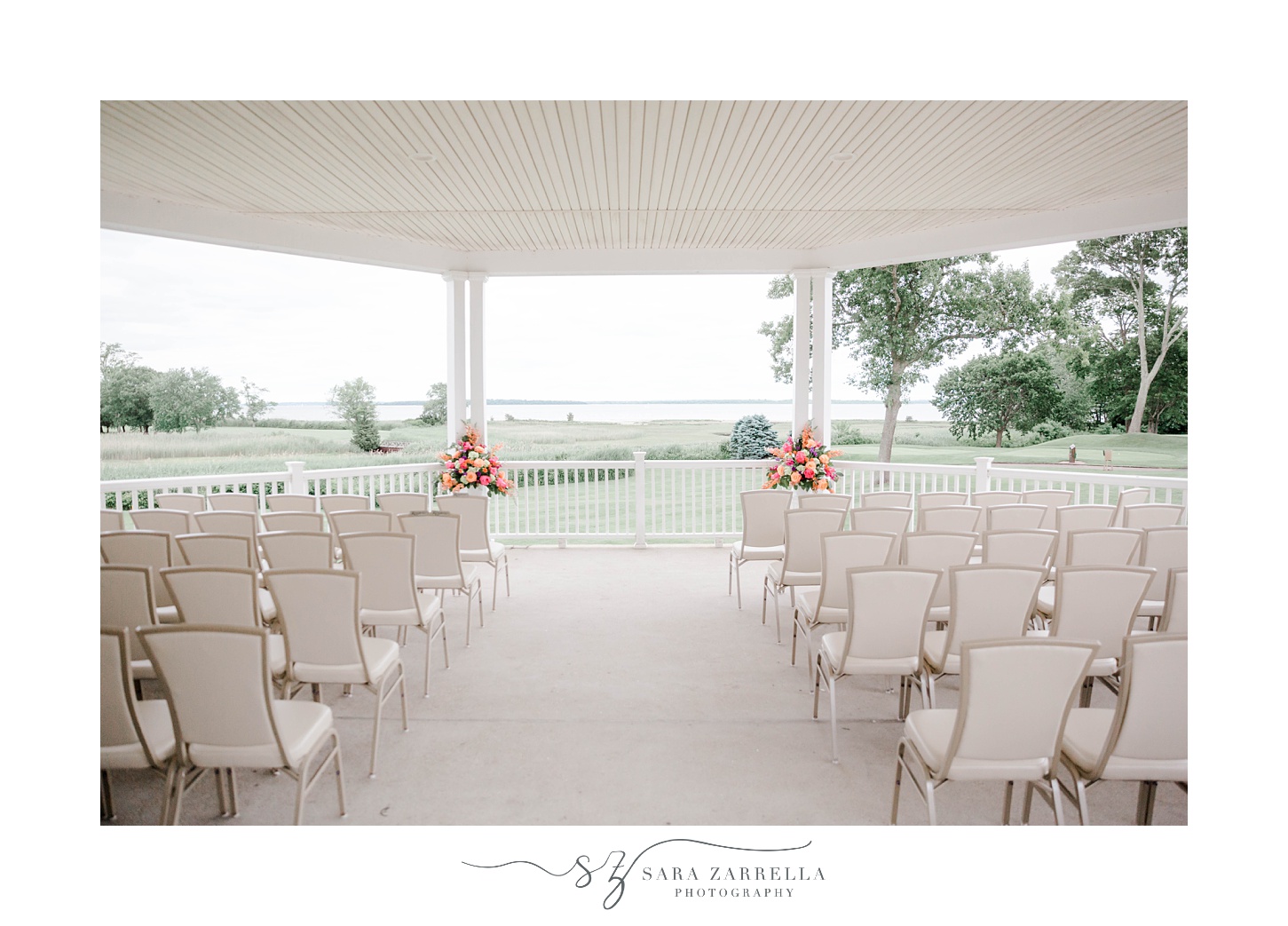 outdoor wedding ceremony with pink and orange flower details at Quidnessett Country Club