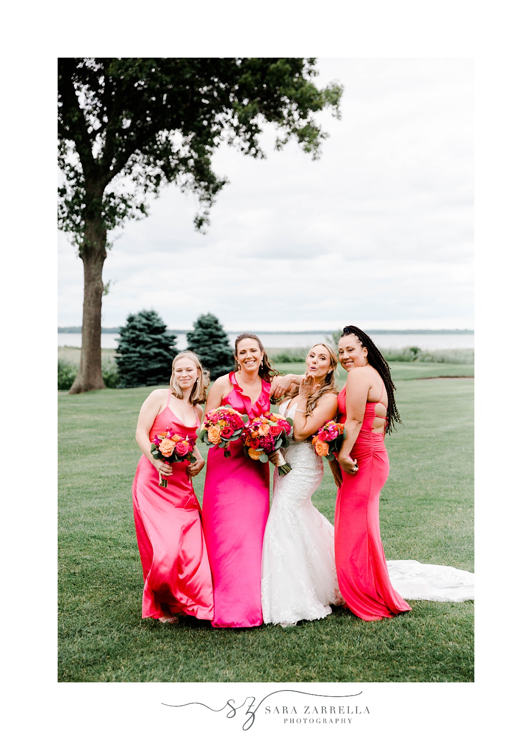bride and bridesmaids pose in bright pink gowns at Quidnessett Country Club