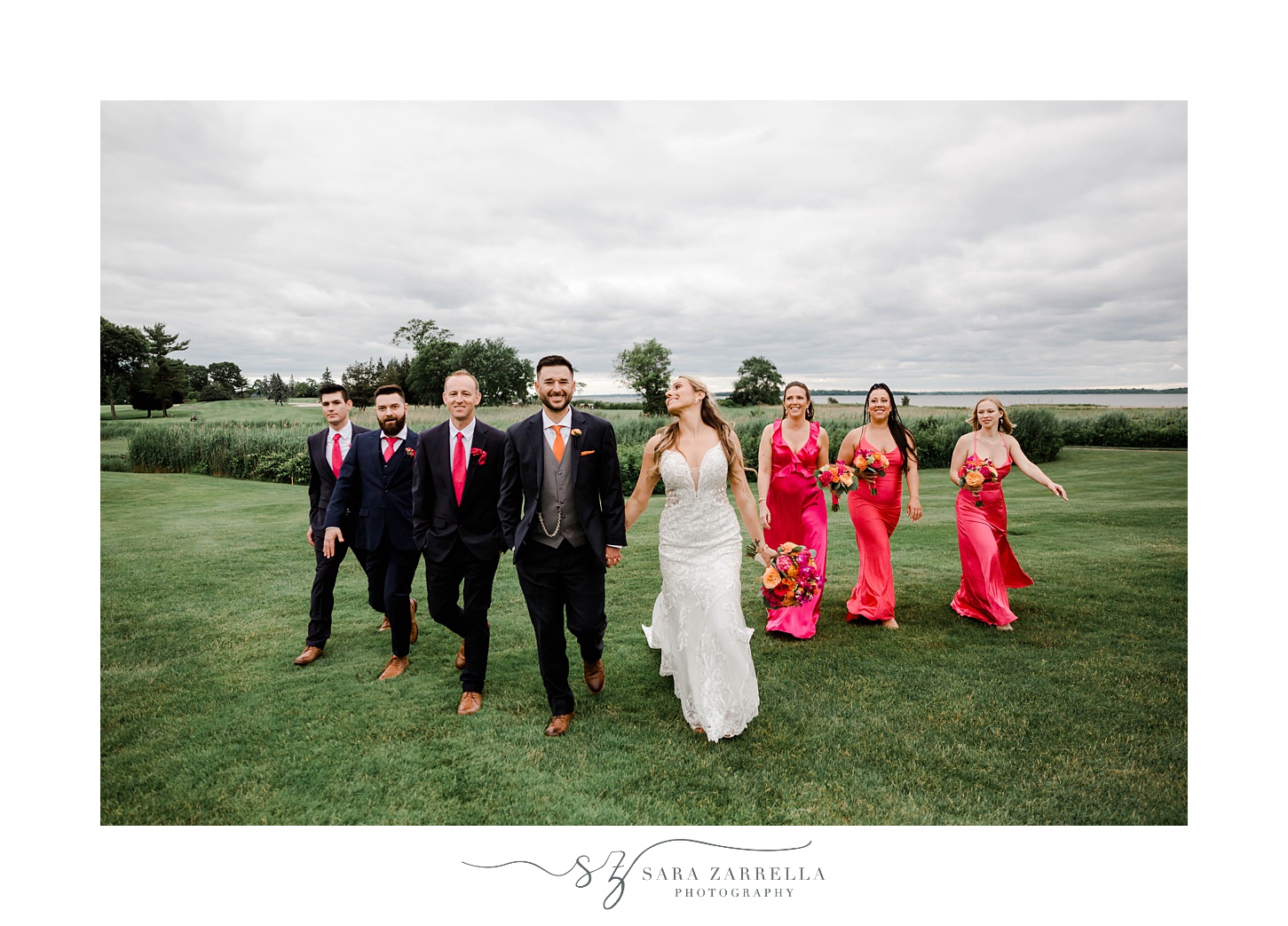 bride and groom laugh walking with bridesmaids in pink gowns and groomsmen in black suits 
