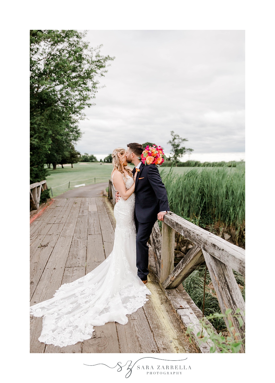 bride and groom kiss on wooden bridge