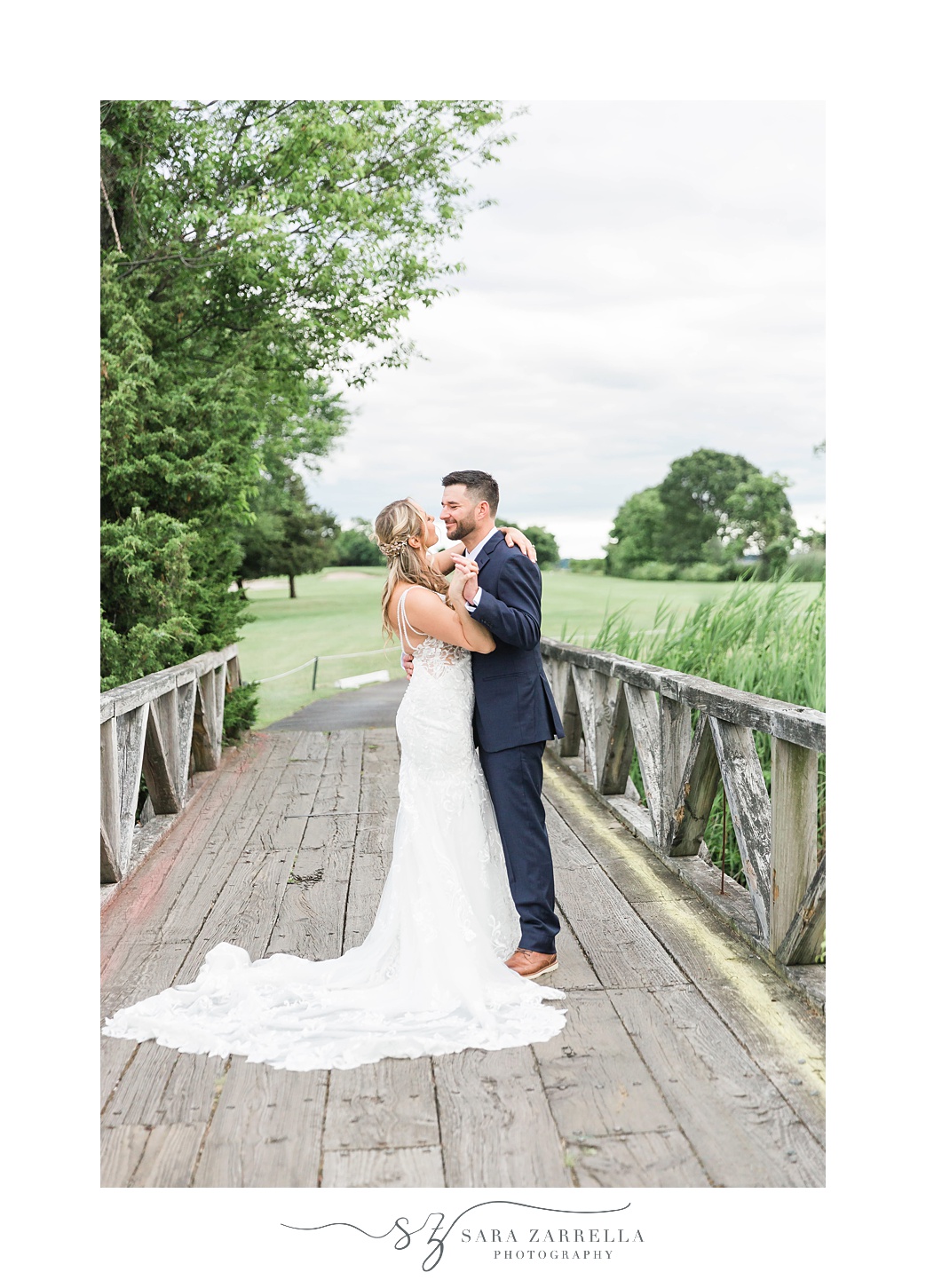bride and groom smile together on bridge at Quidnessett Country Club