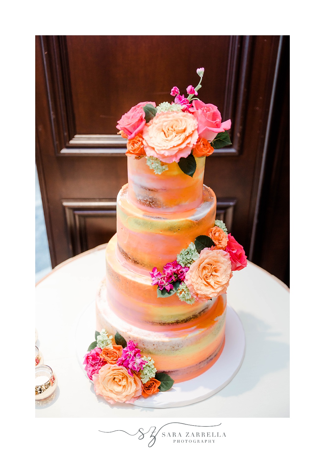 tiered wedding cake with pink and orange flowers at Quidnessett Country Club