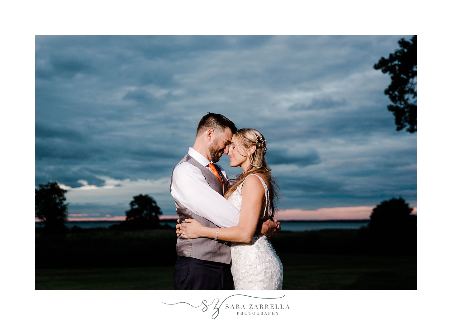 bride and groom hug with heads touching during nighttime portraits in Rhode Island