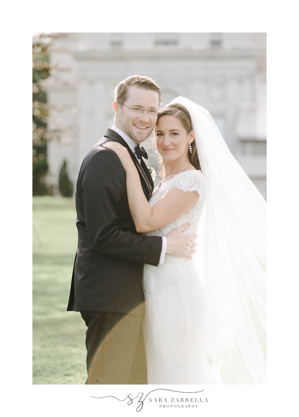 couple hugs together on lawn at Rosecliff Mansion