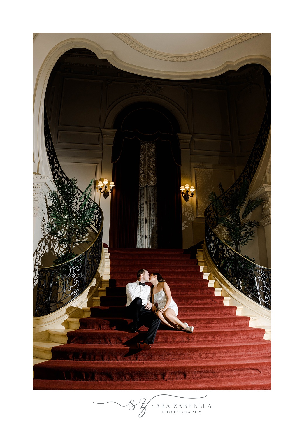 bride and groom sit on staircase at end of wedding day in Rosecliff Mansion