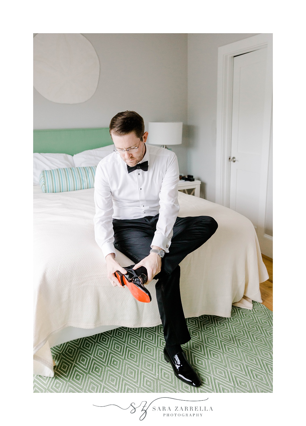groom puts on new shoes during prep for RI wedding day