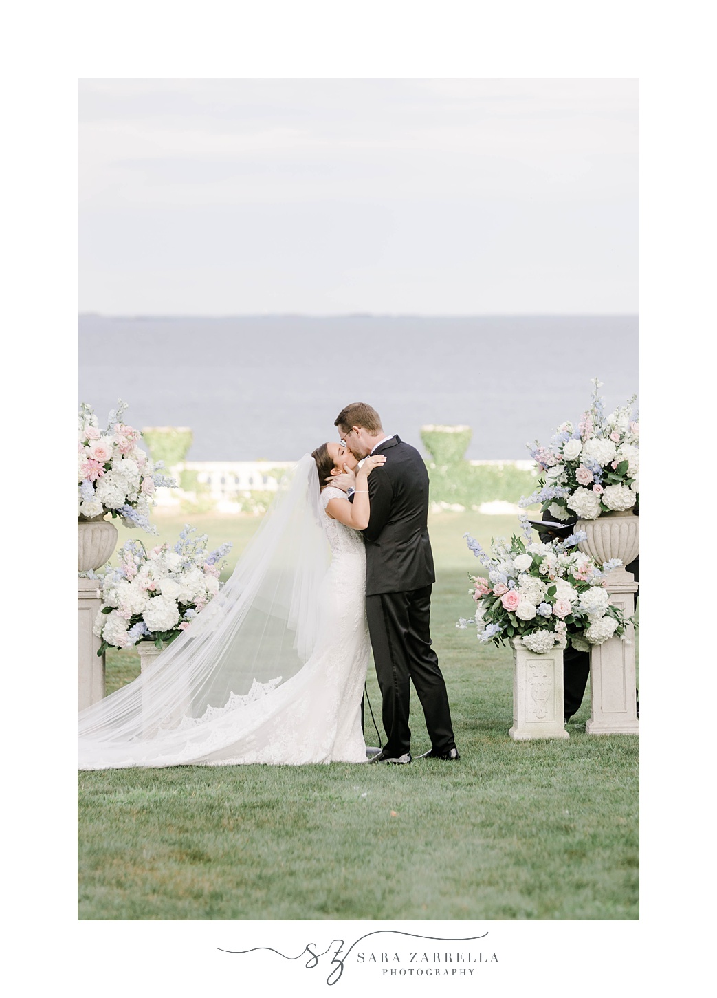 newlyweds kiss during waterfront ceremony at Rosecliff Mansion