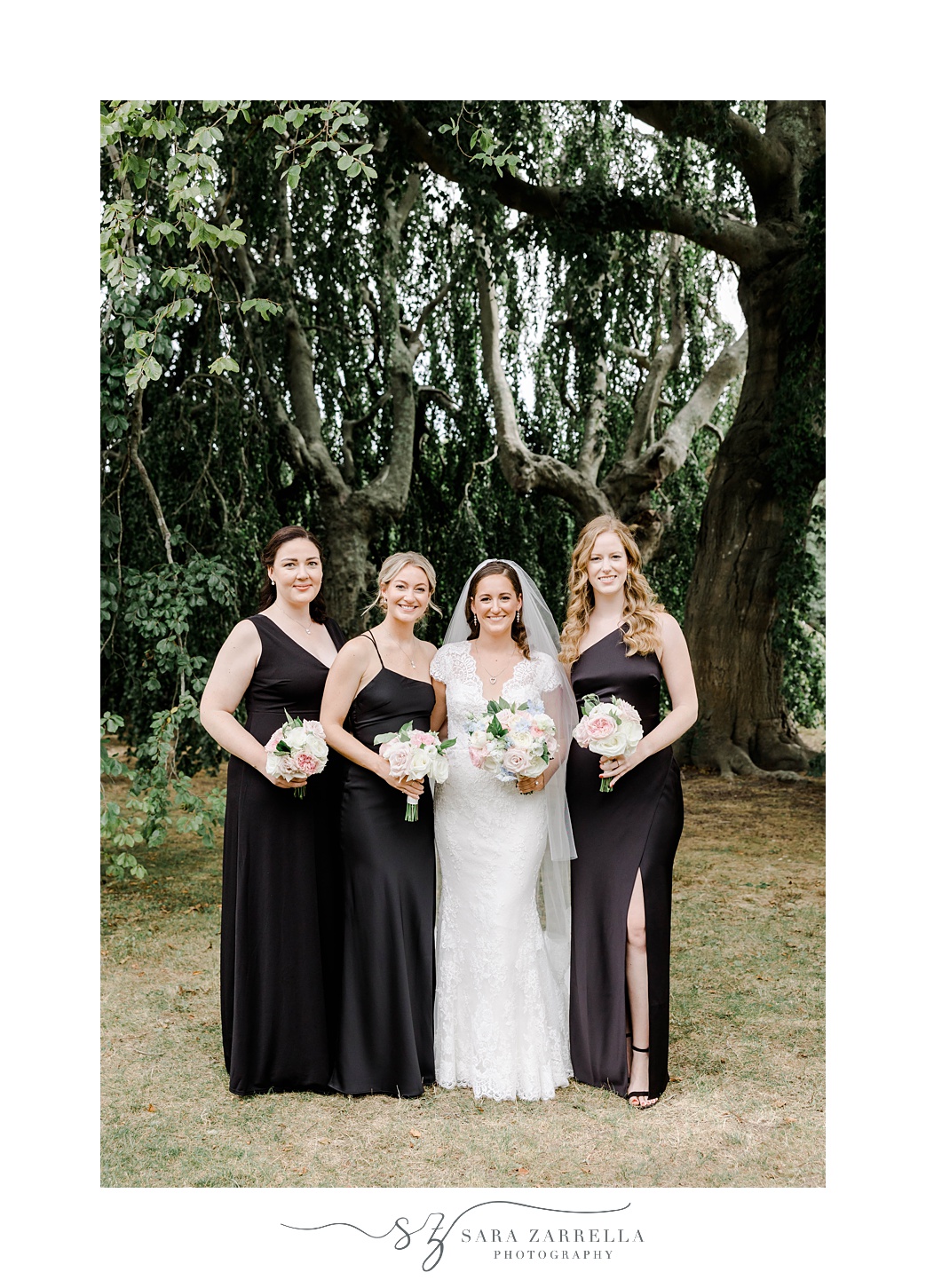 bride poses with bridesmaids in black gowns at The Elms