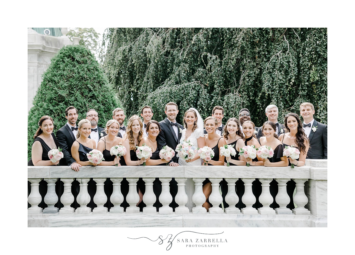 bride and groom stand with wedding party along stone banister at The Elms