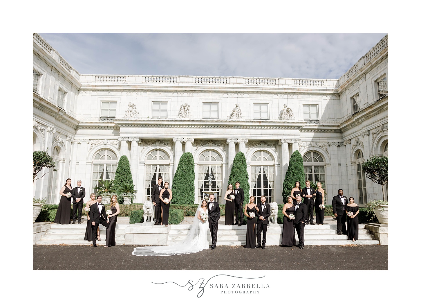bride and groom stand with wedding party in front of mansion at The Elms