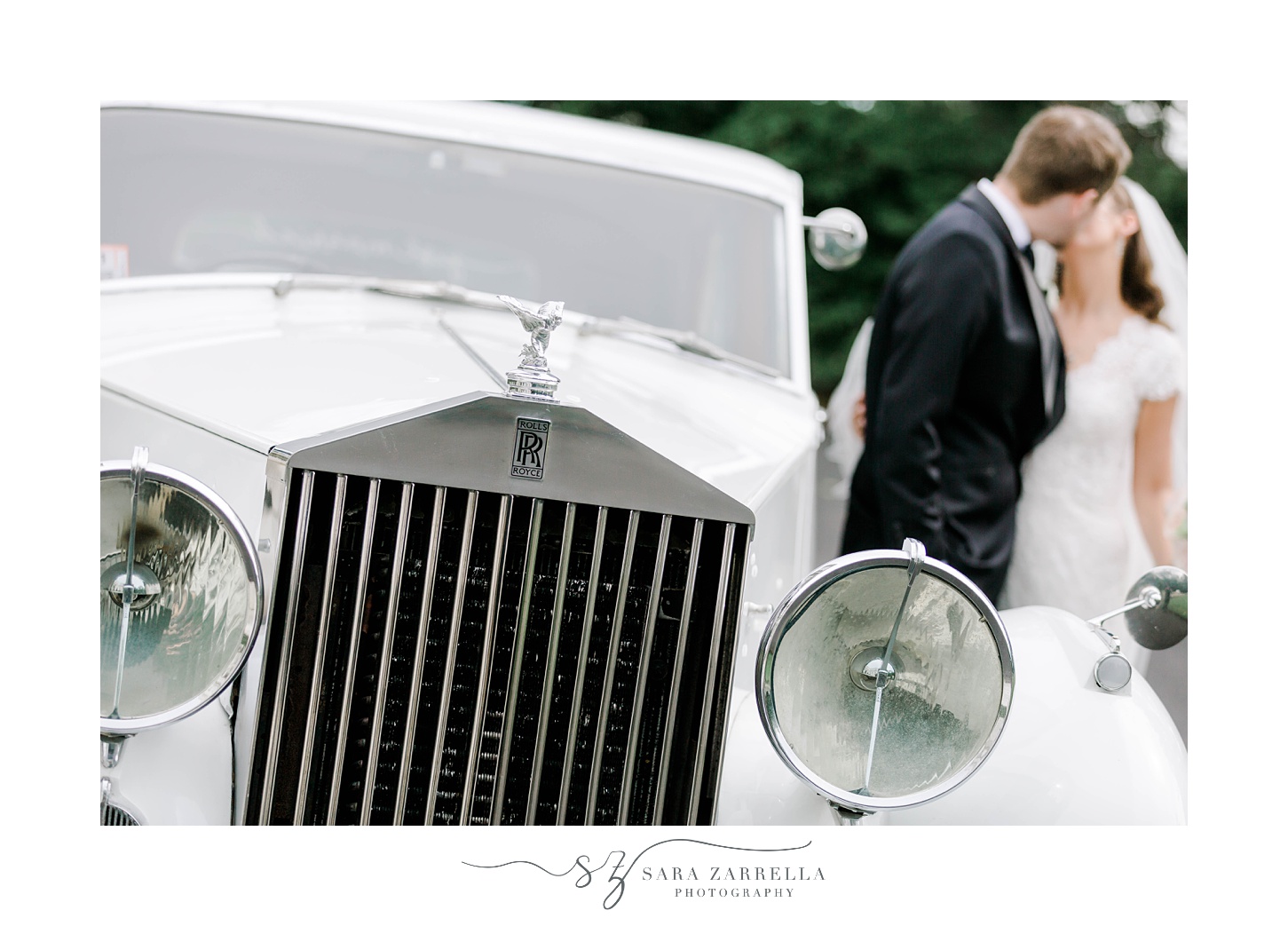 bride and groom kiss by classic car at Rosecliff Mansion