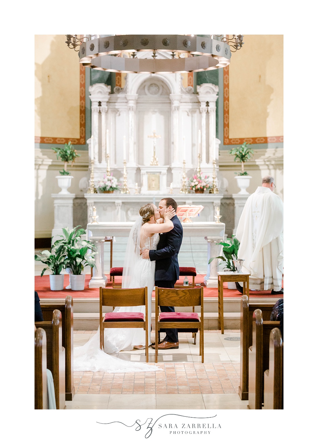 bride and groom kiss during traditional Catholic Church wedding in Rhode Island