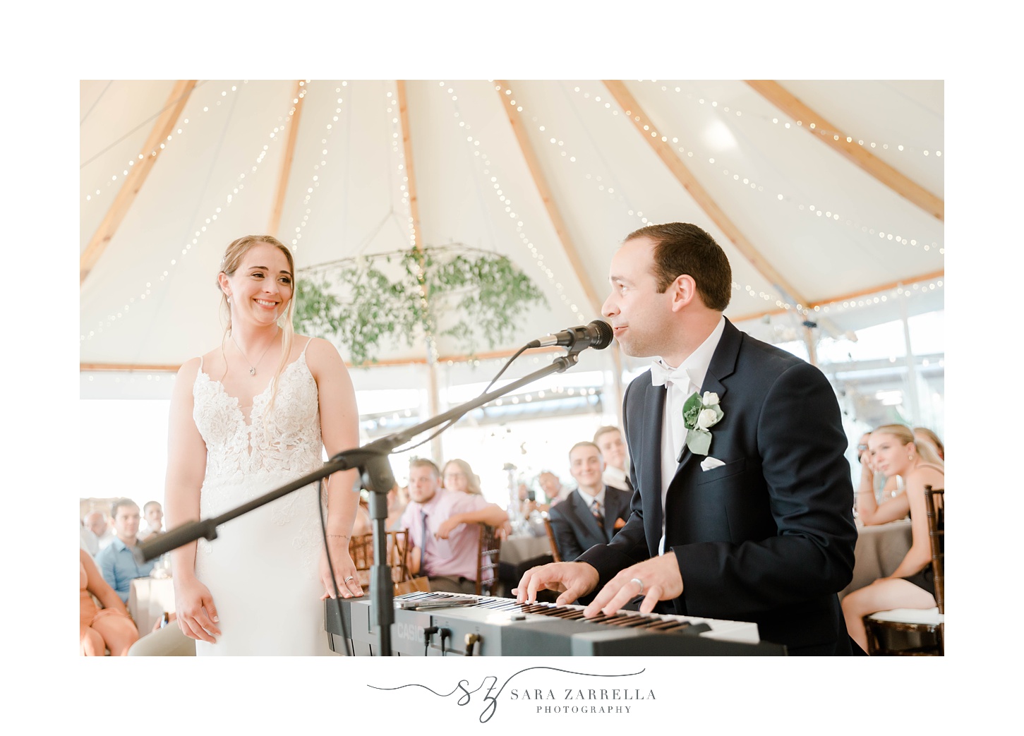 groom plays piano singing to bride during Newport wedding reception