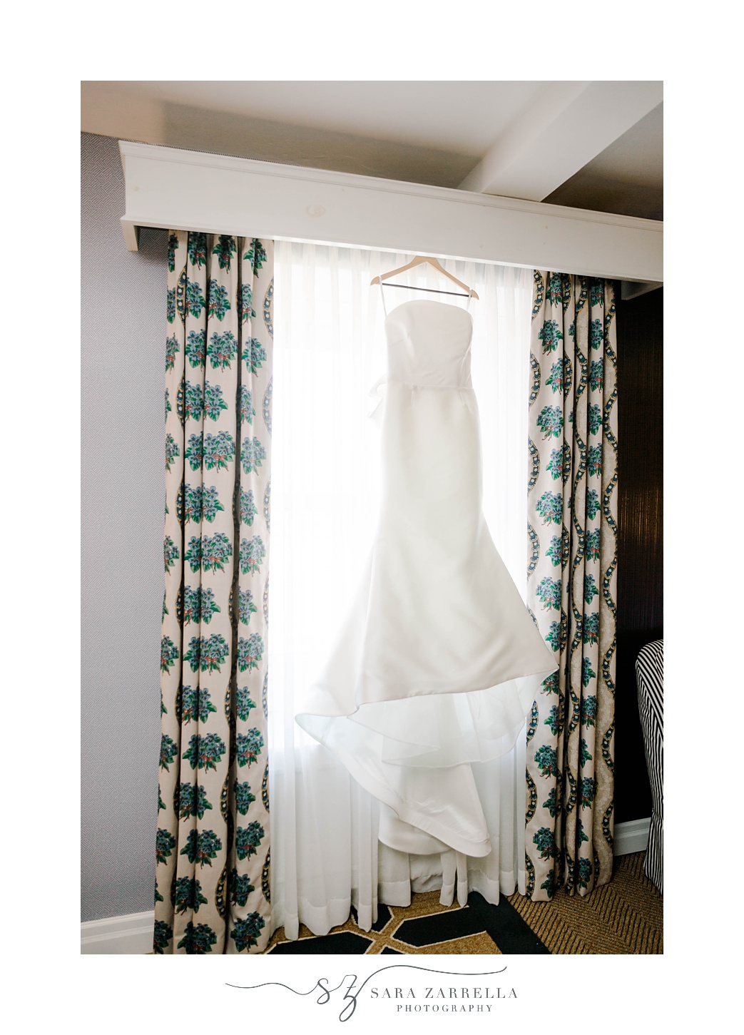 wedding dress hangs in Rhode Island hotel in window