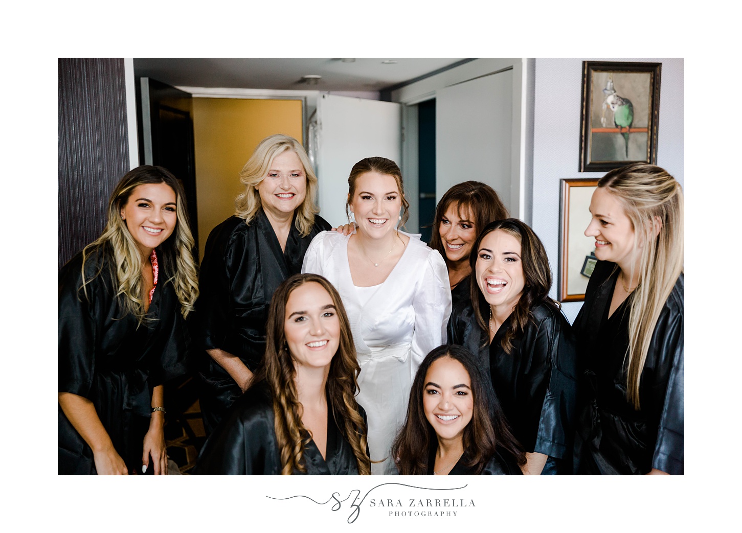 bride stands with seven bridesmaids in black robes 