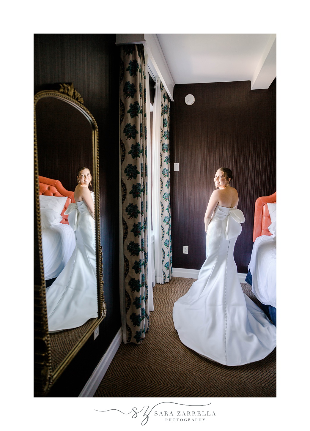 bride looks over shoulder into hotel mirror in Rhode Island