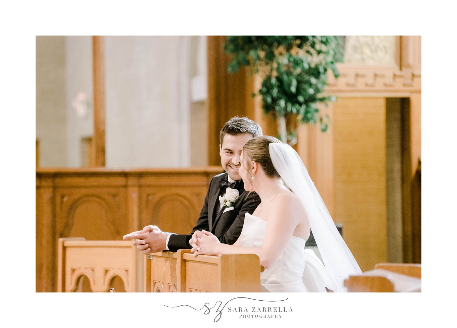 newlyweds smile together kneeling during traditional ceremony at Aldrich Mansion chapel