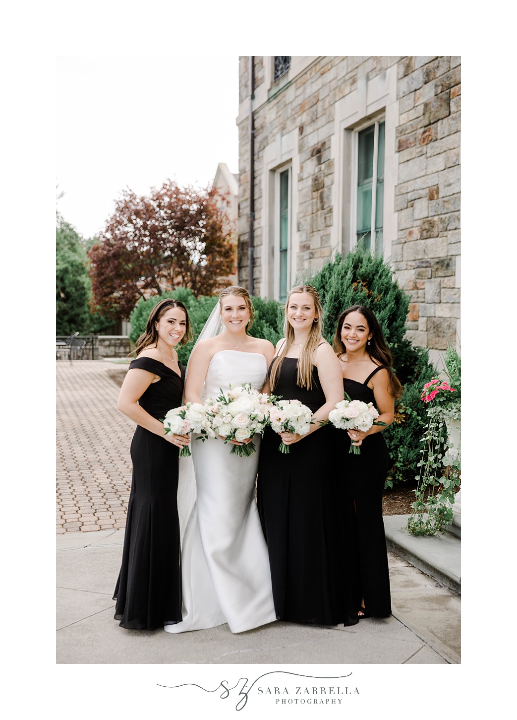 bride stands with bridesmaids in black gowns outside Aldrich Mansion