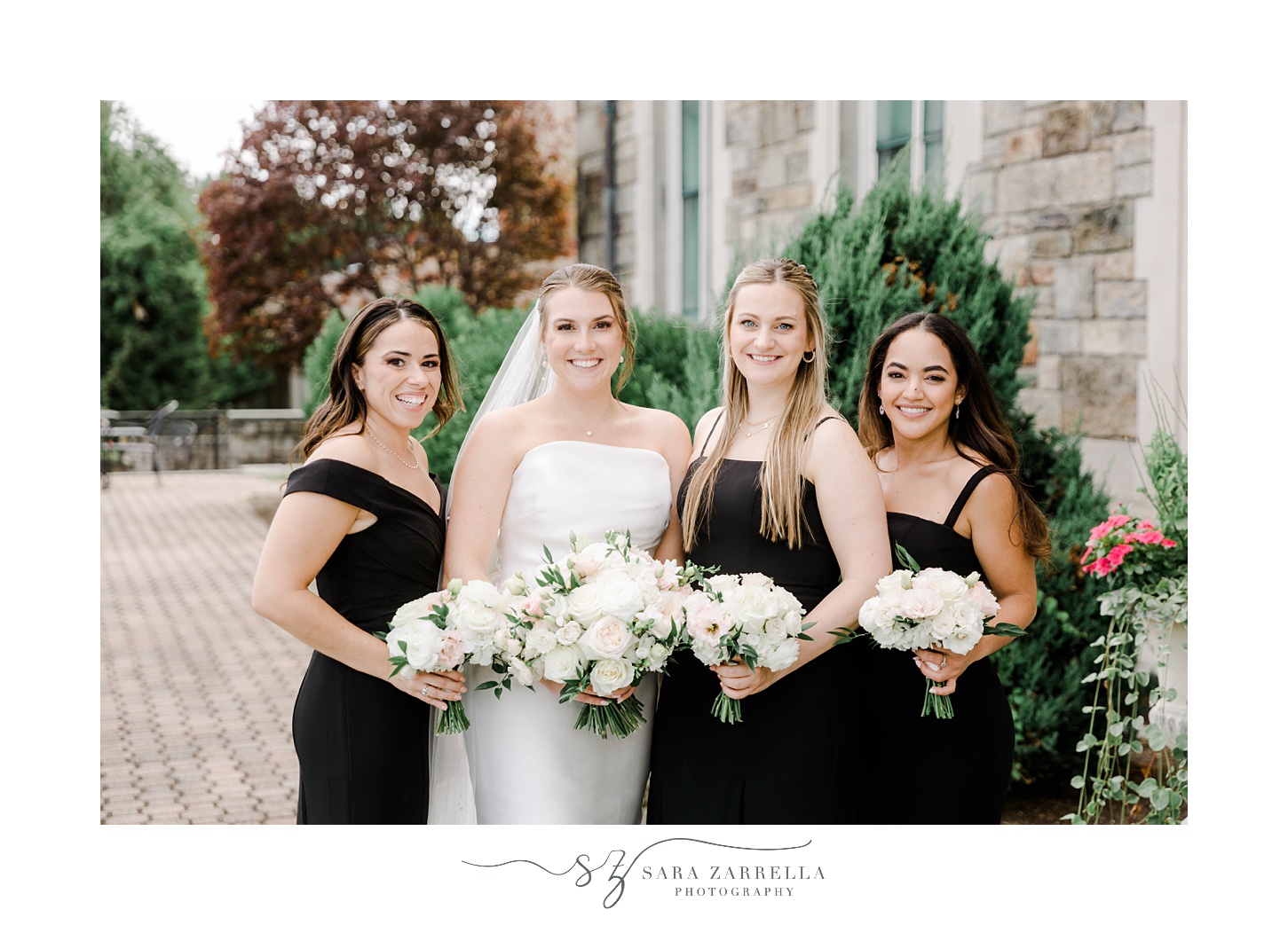 bride and bridesmaids in black gowns smile outside Aldrich Mansion