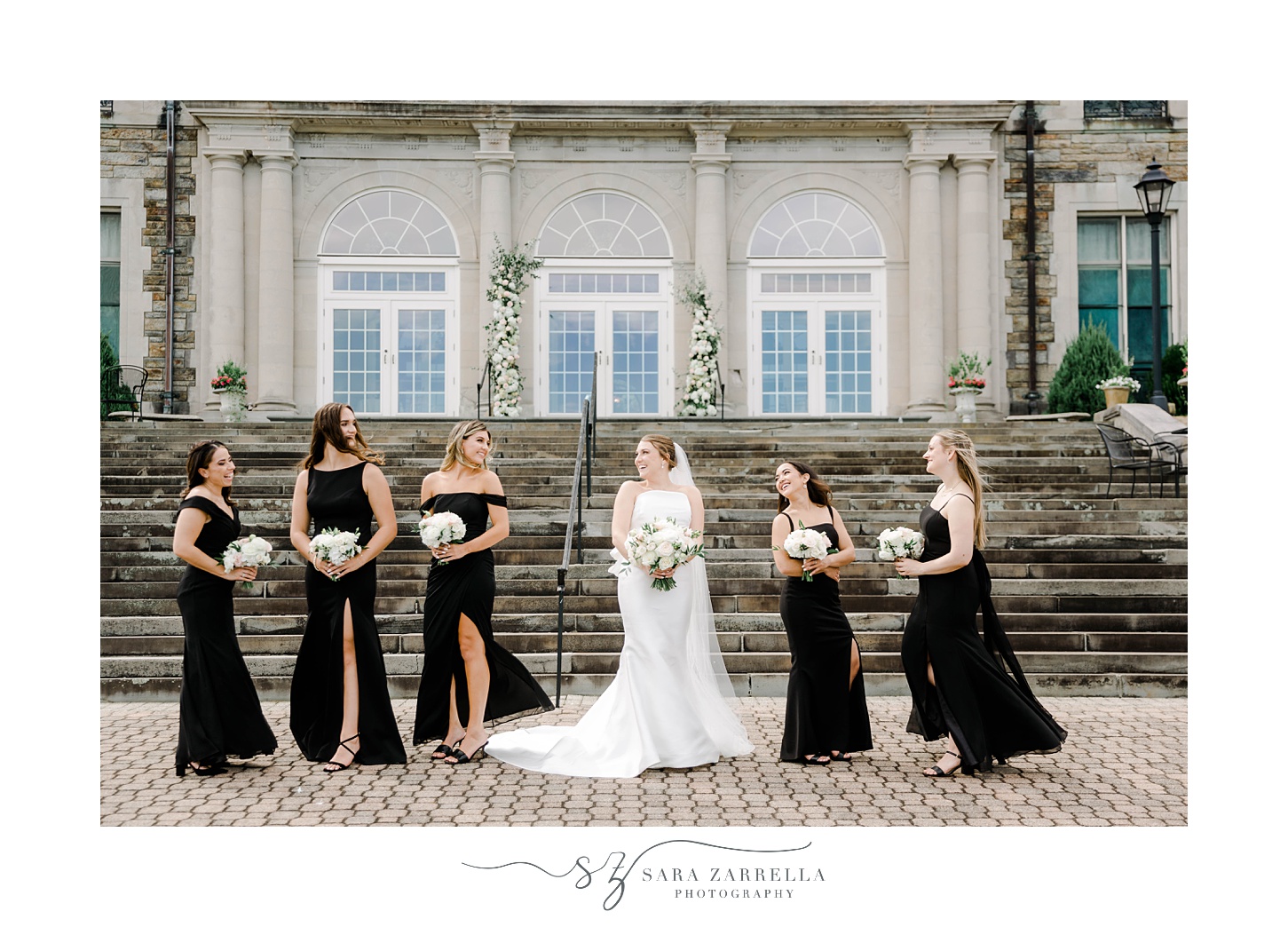 bride laughs with bridesmaids outside staircase at Aldrich Mansion