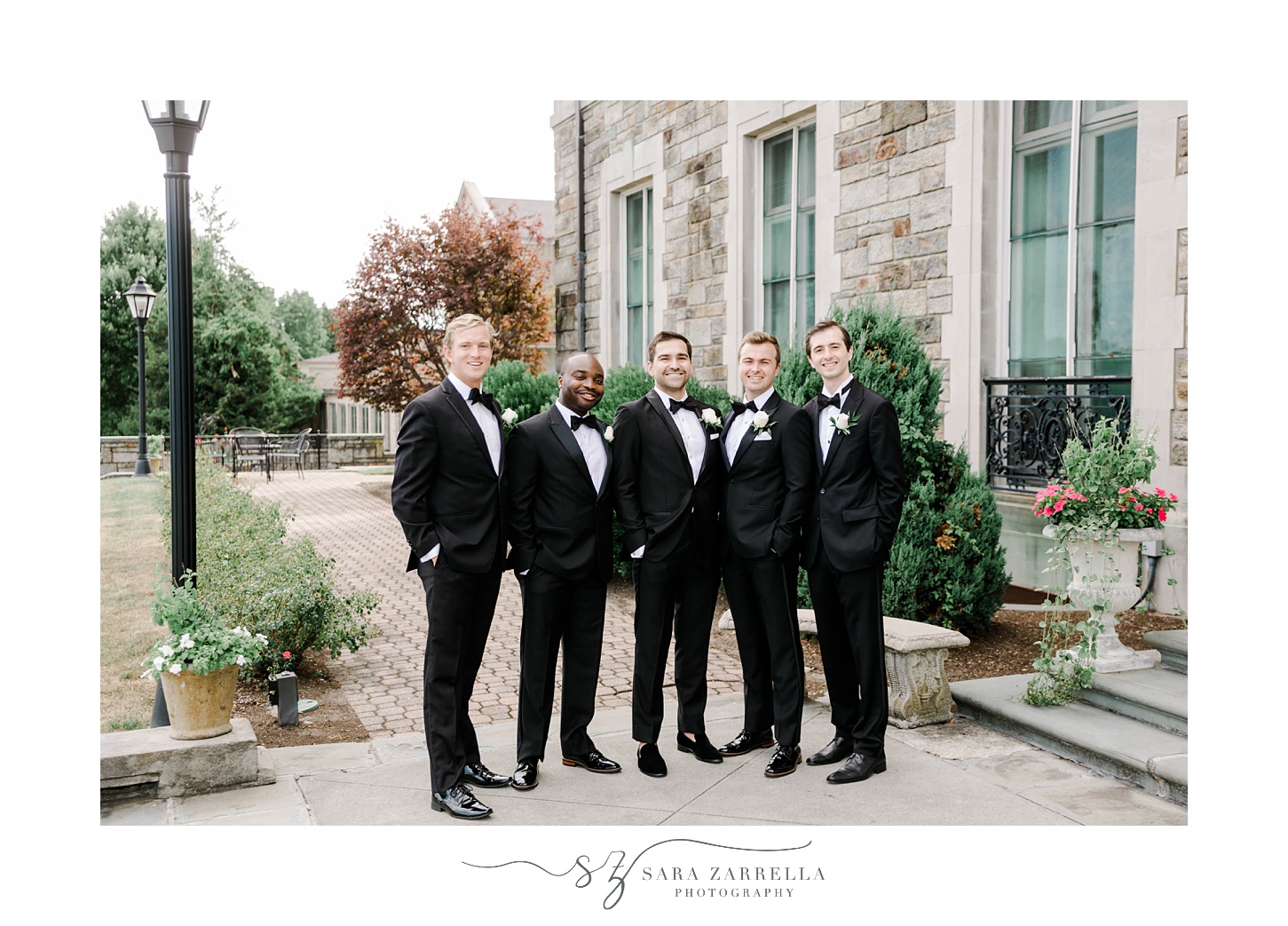 groom and groomsmen stand in classic tuxes outside Aldrich Mansion
