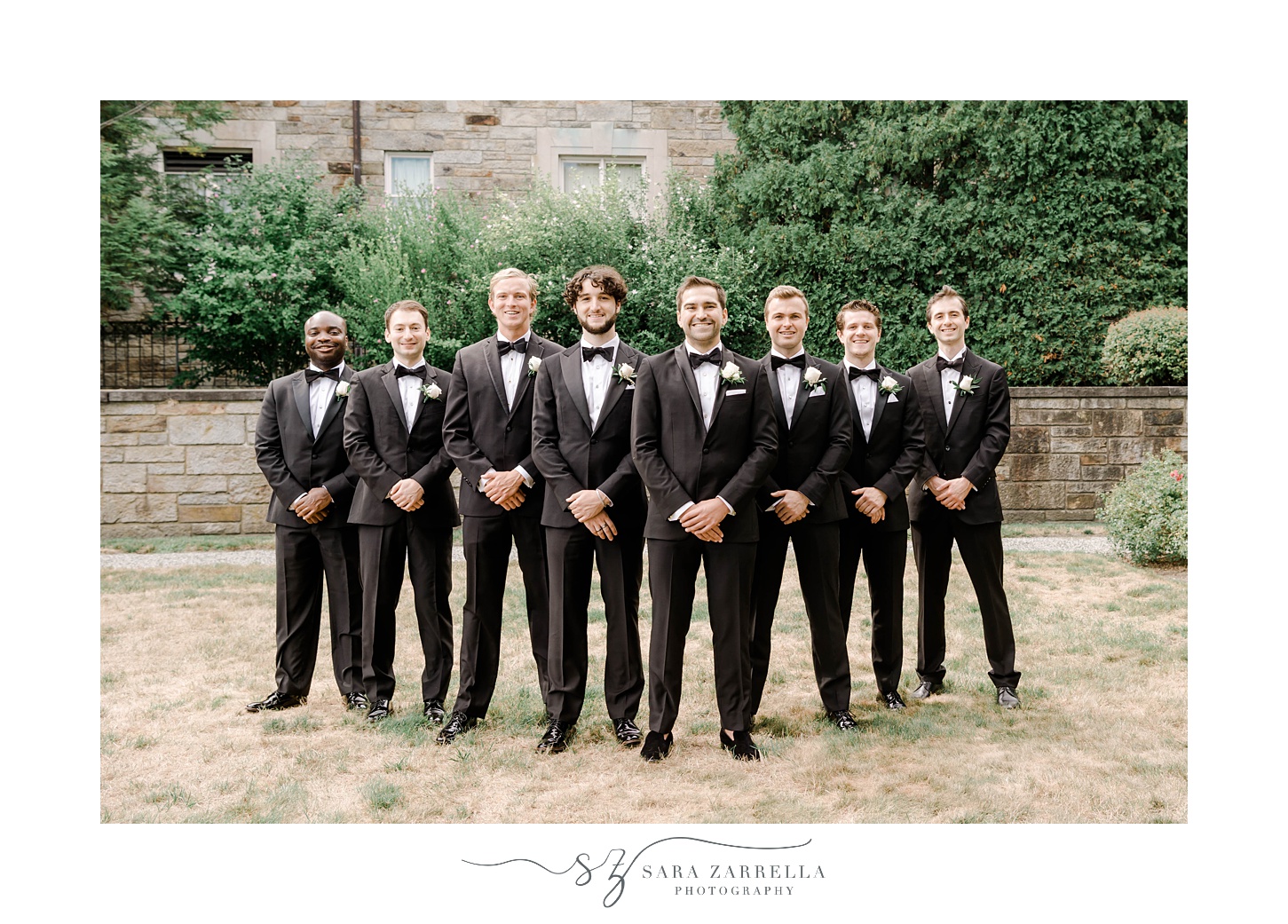 groom stands with groomsmen in V formation