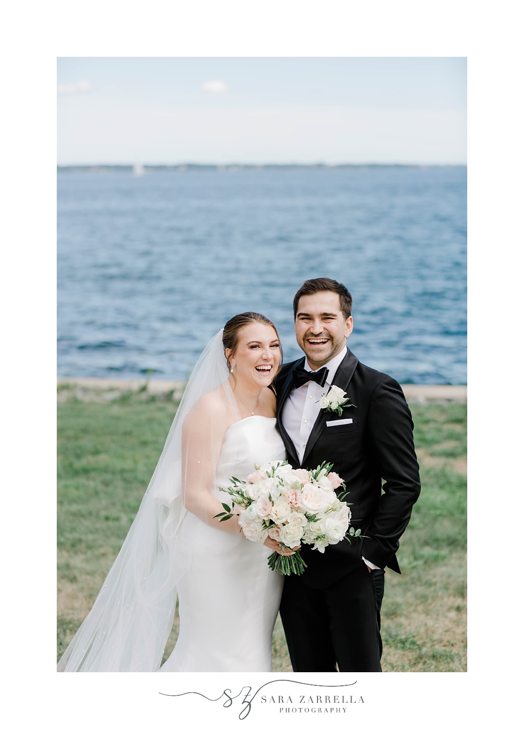bride and groom laugh together along waterfront in Warwick RI