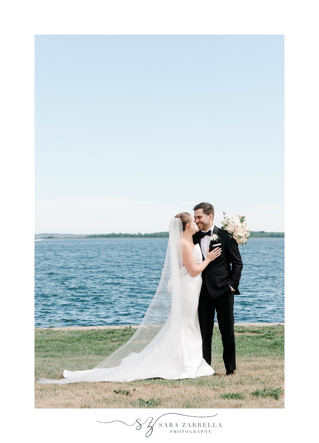 bride and groom kiss along waterfront in Warwick RI