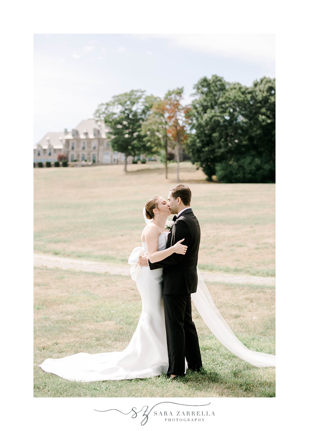 bride and groom kiss on lawn outside Aldrich Mansion