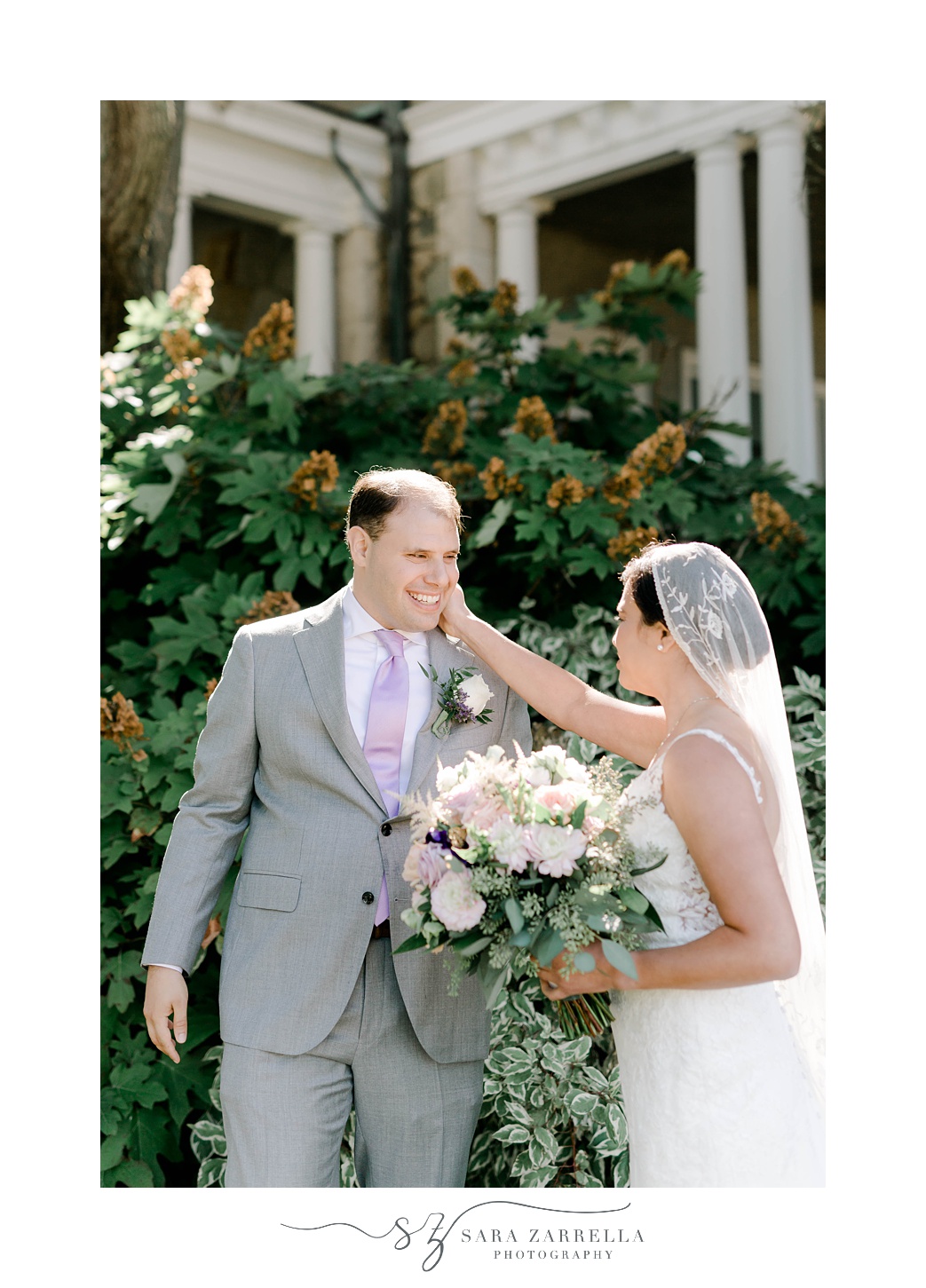 bride touches groom's cheek during first look outside Blithewold Mansion