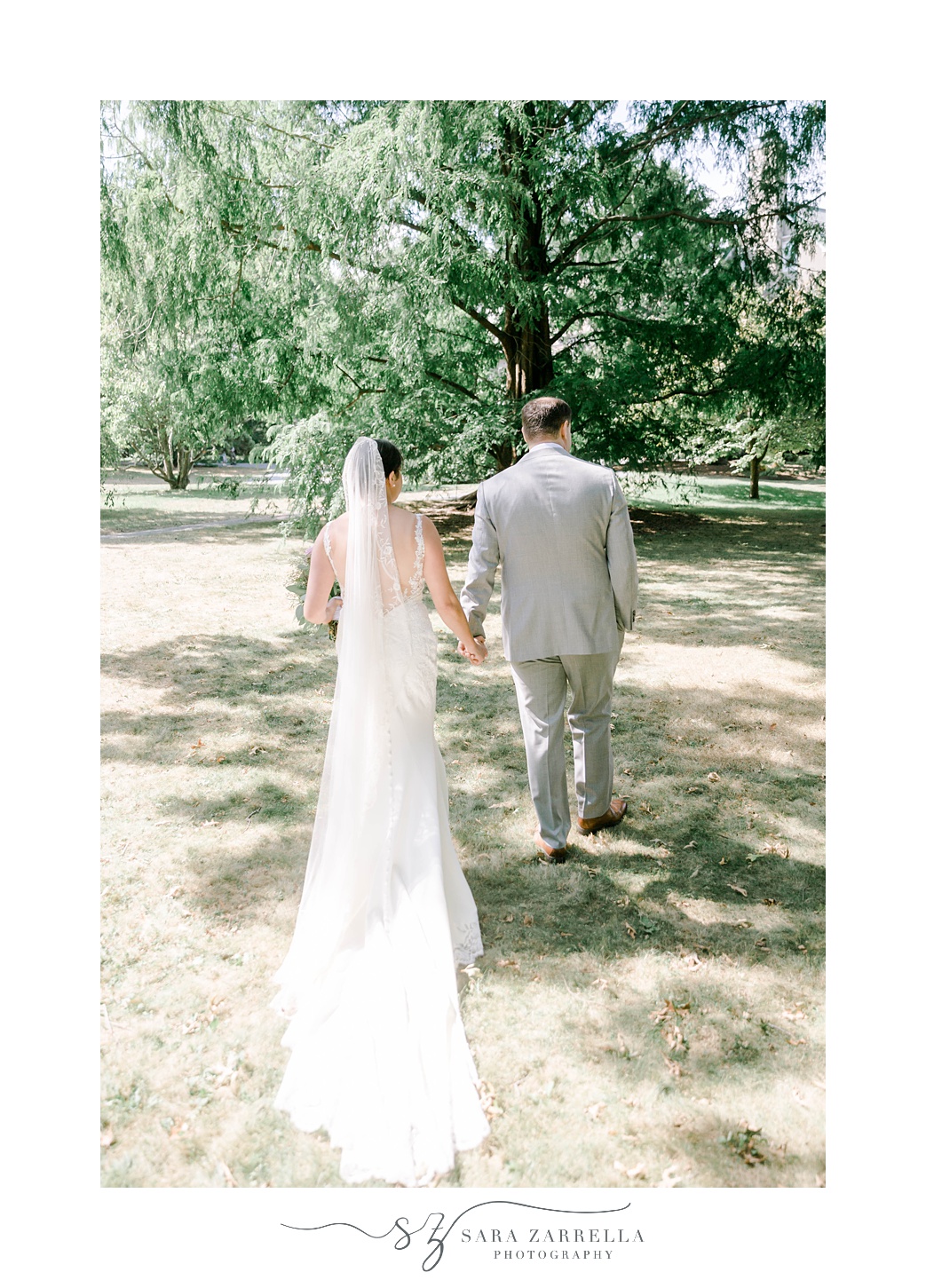 bride and groom hold hands walking on lawn at Jewish wedding ceremony at Blithewold Mansion