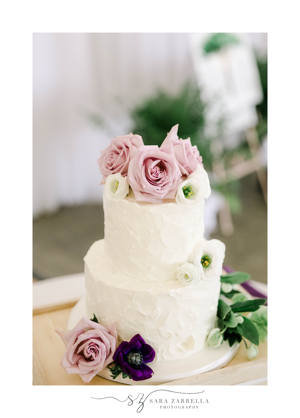 tiered wedding cake with purple and pink flower accents