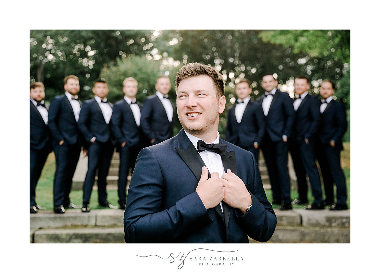 groom stands in front of groomsmen with navy suit at Glen Manor House