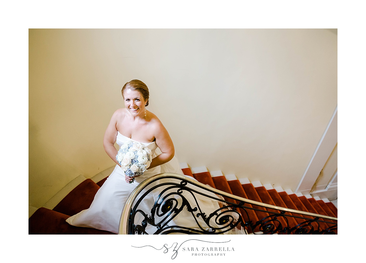 bride stands on staircase inside Glen Manor House with red carpet 