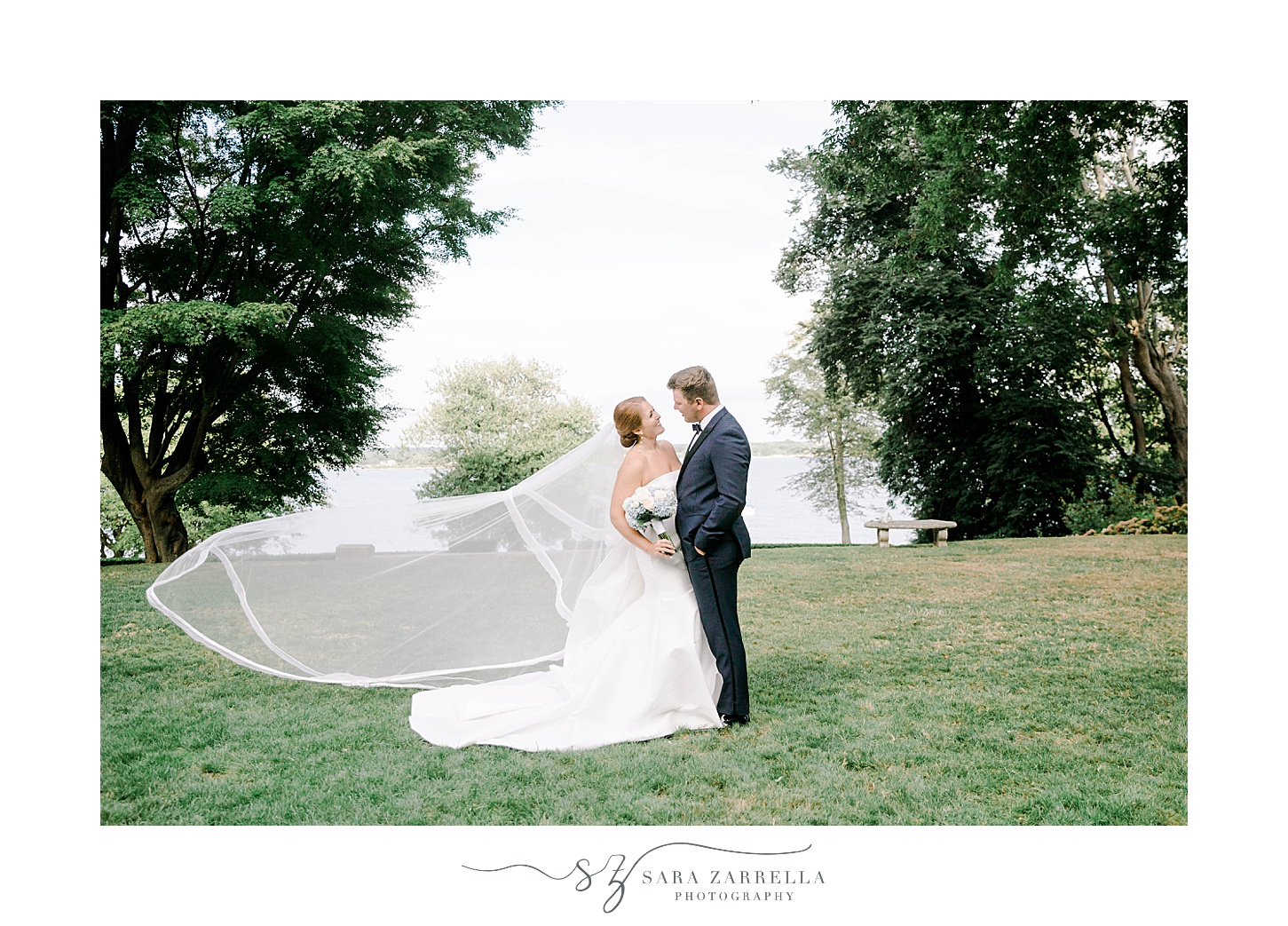 bride and groom stand on lawn at Glen Manor House with veil floating