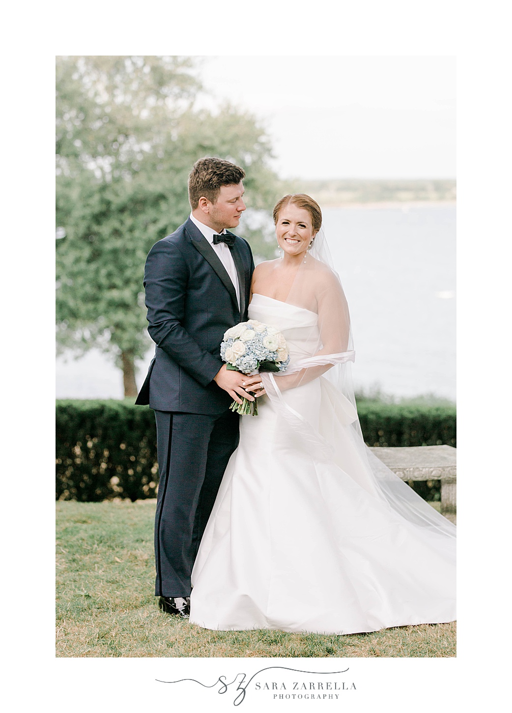groom smiles at bride along waterfront at Glen Manor House