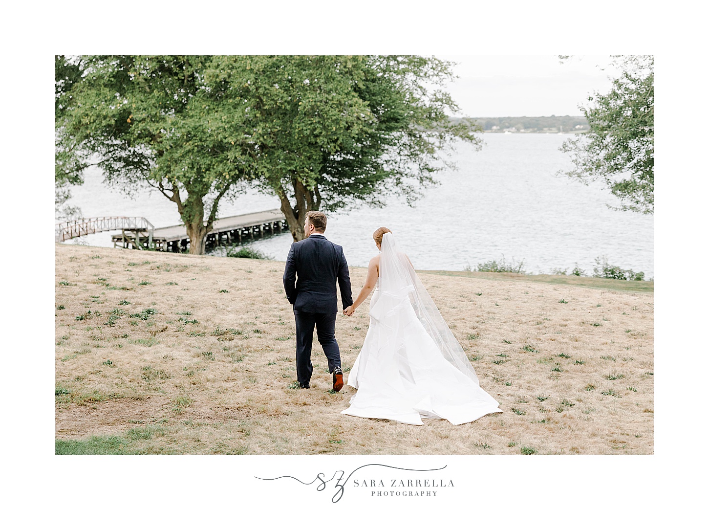 bride and groom hold hands walking by water at Glen Manor House