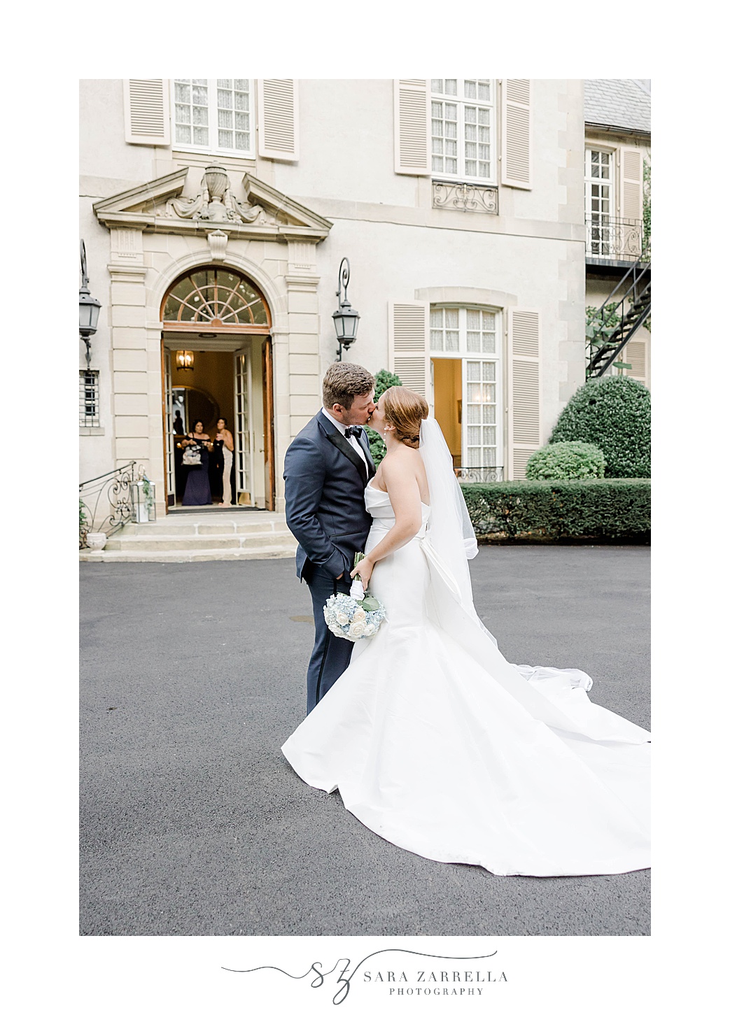 bride and groom kiss in front of Glen Manor House
