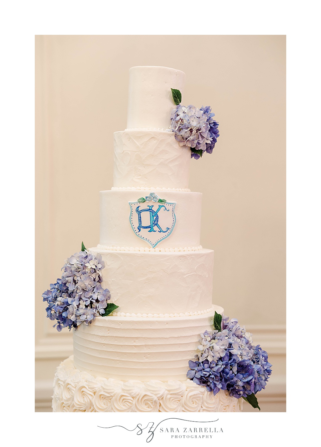 tiered wedding cake with blue and white details 