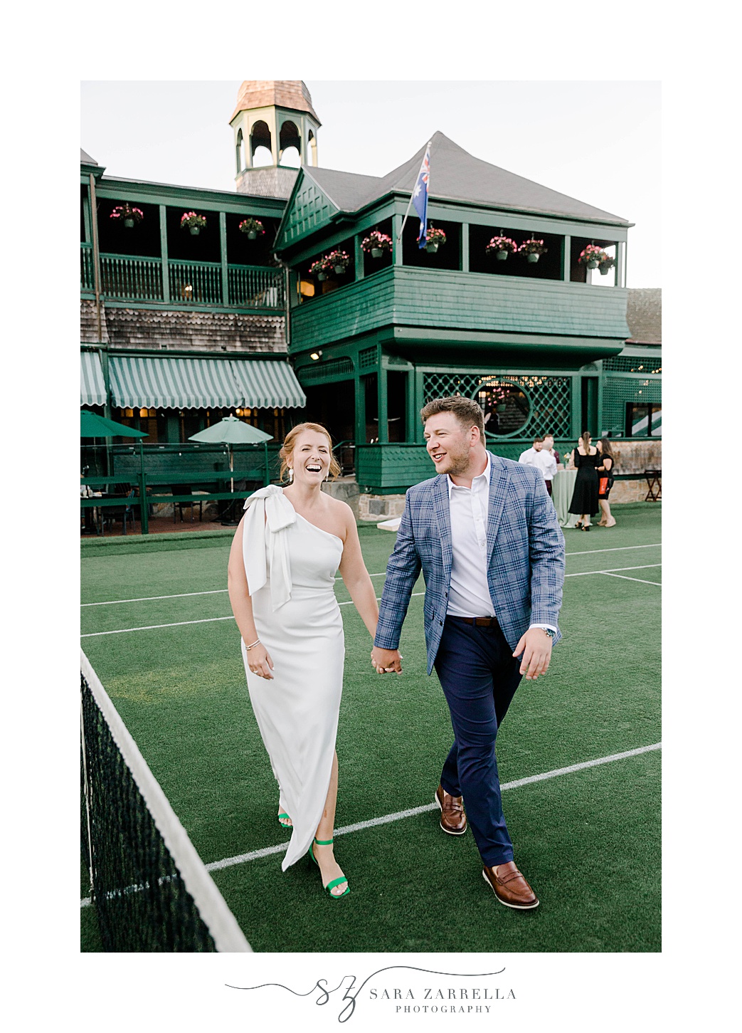 couple laughs walking on tennis court at The International Tennis Hall of Fame